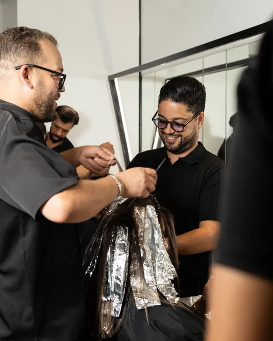 Ayoub et un coiffeur posent des mèches au papier aluminium