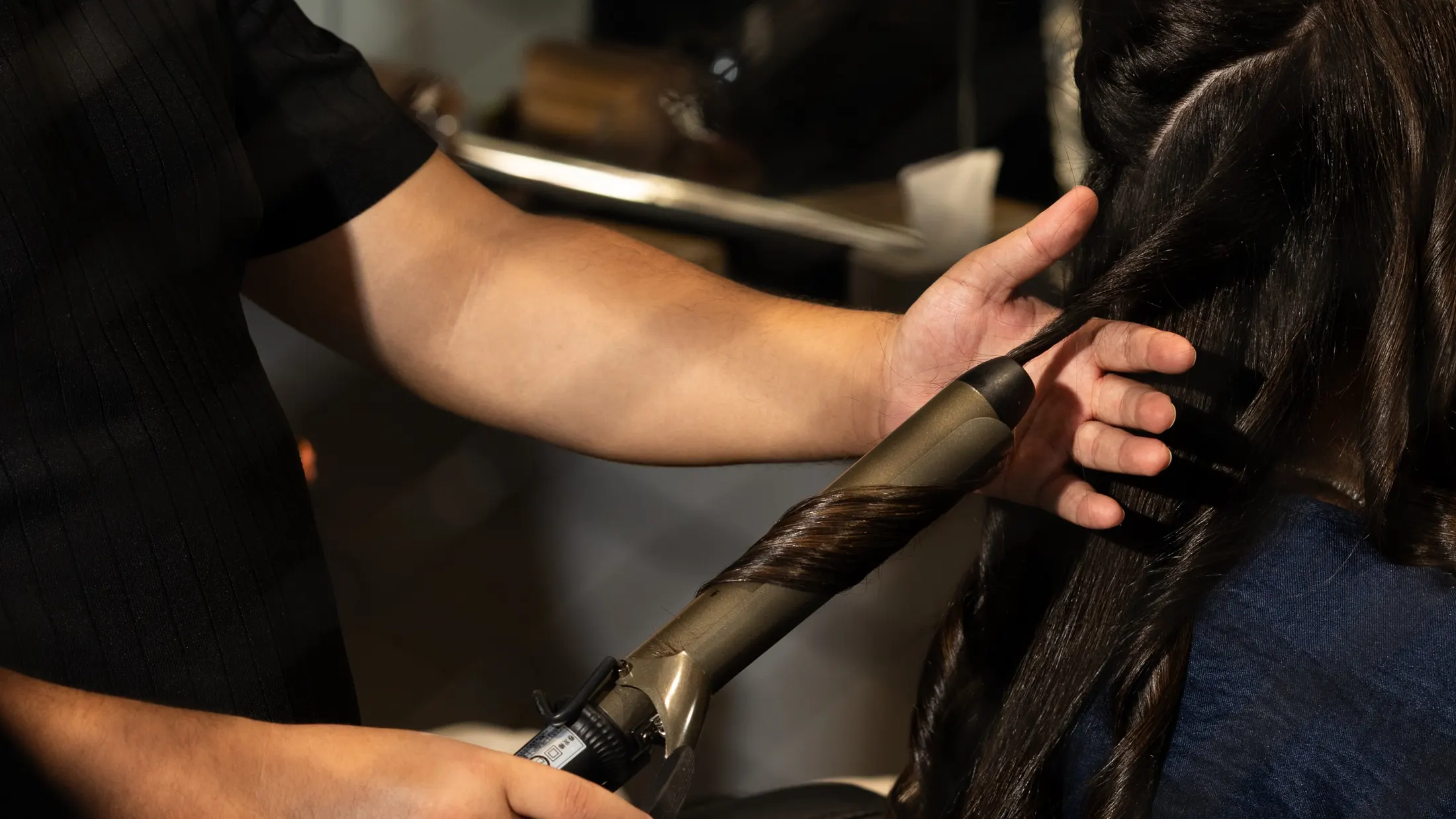 Boucles au fer sur cheveux longs et foncés, au salon